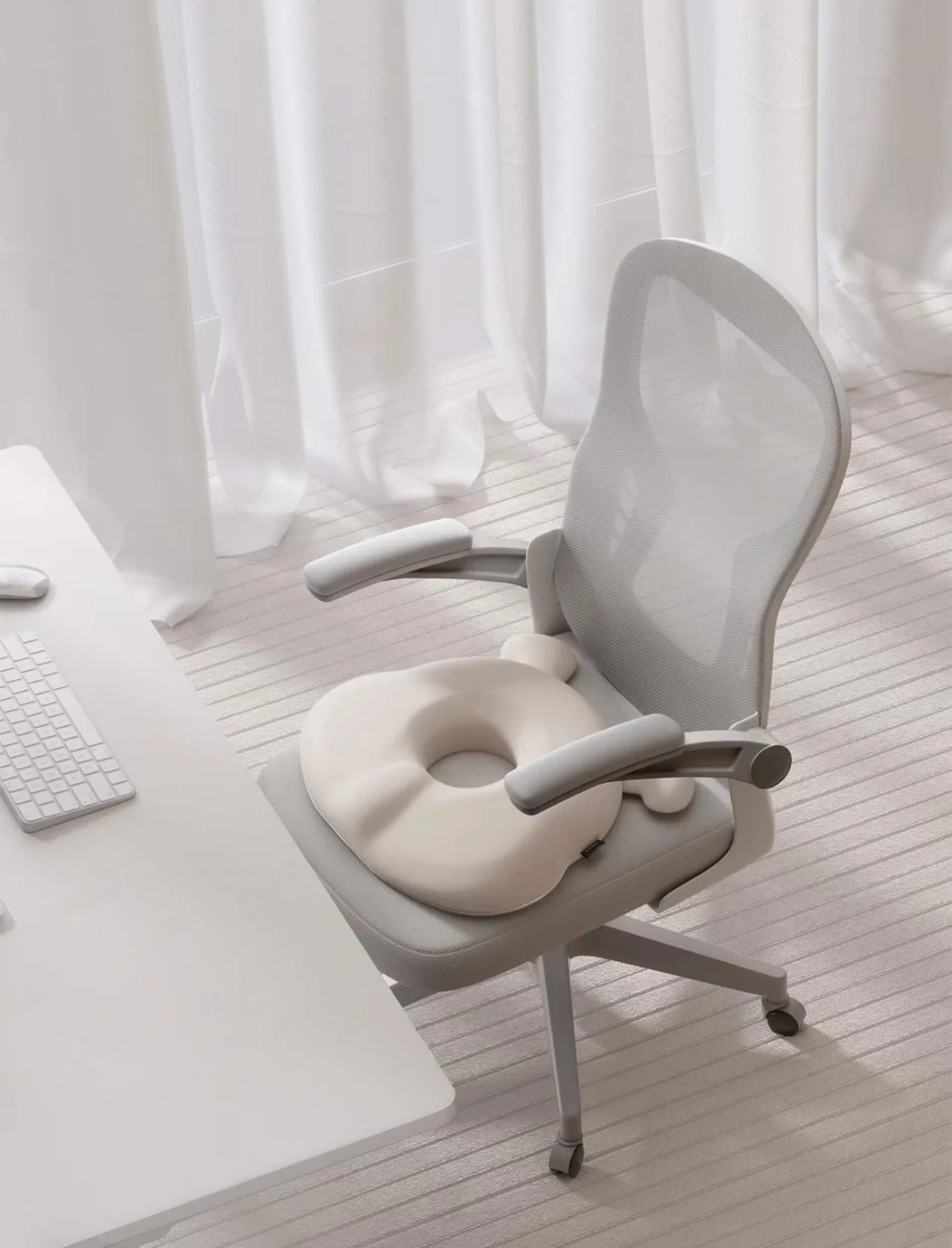 A pale ergonomic office chair in a quiet translucent workspace